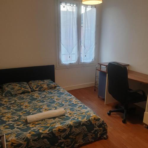 une chambre avec un lit, un bureau et une chaise dans l'établissement Appartement 2 chambres proche gare, à Besançon