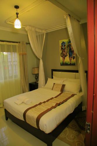 a bedroom with a large bed in a room at Royal Victoria House Ltd in Kampala