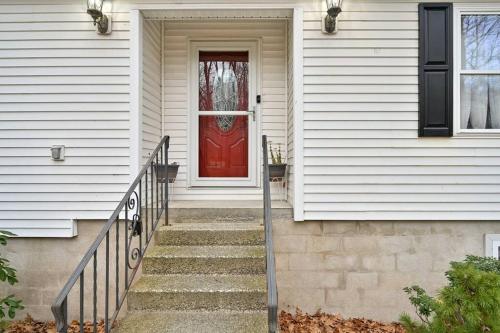 a red door on a white house with stairs at Poconos Peaceful Retreat - Families & Large Groups in Tobyhanna