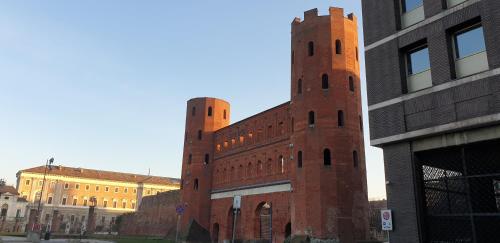 um edifício de tijolos com duas torres do lado em Romantica mansarda nel cuore di Torino em Turim