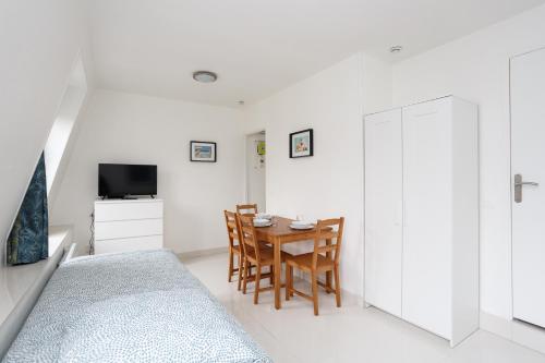 a bedroom with a table and chairs and a television at Bourget RER Studio 2ème droite in Le Bourget