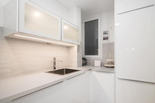 uma cozinha branca com um lavatório e um frigorífico em Near FCB STADIUM. One car free parking. em Barcelona