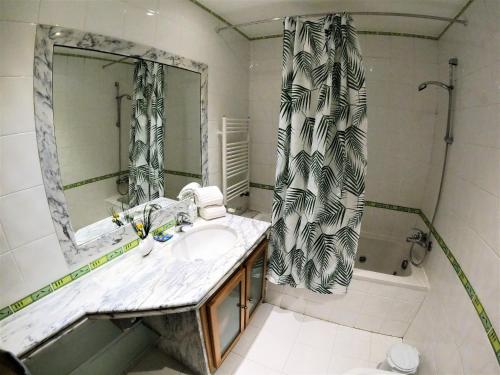 a bathroom with a sink and a mirror and a tub at Lisbon 2 bedroom apartment with balcony in Algés in Algés