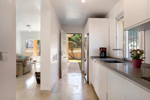 Una cocina blanca con fregadero y encimera. en Villa Germany, en Poblado de Sancti Petri