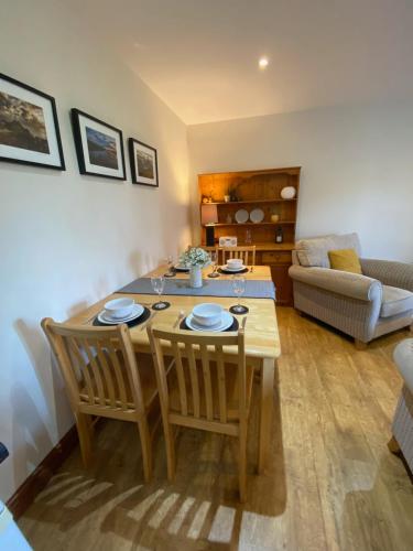 a living room with a wooden table and chairs at 5 Glantraeth Farm Cottage in Bodorgan