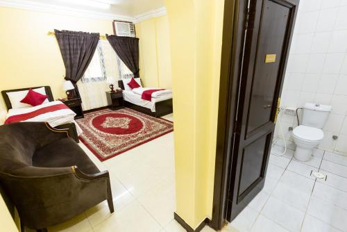 a living room with a chair and a toilet at Al Eairy Apartments - Al Madinah 09 in Medina