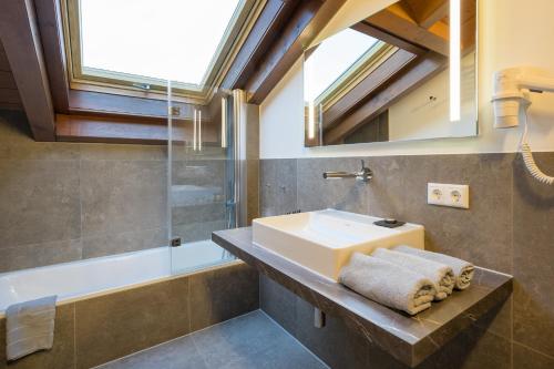ein Bad mit einem Waschbecken und einer Dusche in der Unterkunft Landhaus Kopp in Oberstdorf