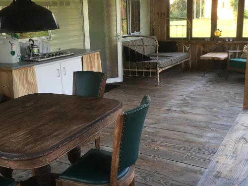 Mobile Home auf Campingplatz mit Naturbadesee في Parsac: غرفة طعام مع طاولة وكراسي خشبية