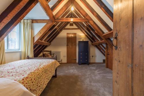 ein Schlafzimmer mit einem Bett in einem Zimmer mit Holzdecken in der Unterkunft Wisteria House, 6 beds Central Uckfield East Sussex in Uckfield