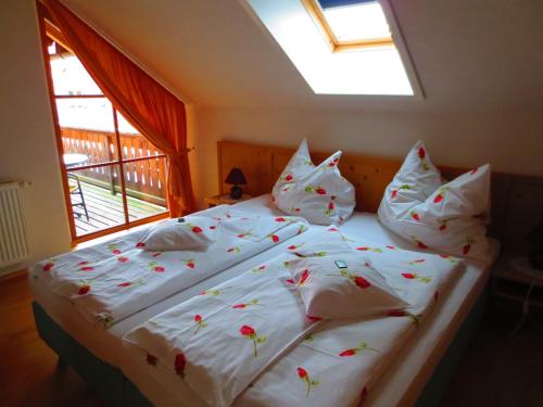 a bed with white sheets and red flowers on it at Sportlerhof in Grünau im Almtal