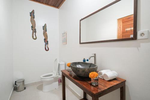 La salle de bains est pourvue d'un lavabo, de toilettes et d'un miroir. dans l'établissement Villa Felise, à anur