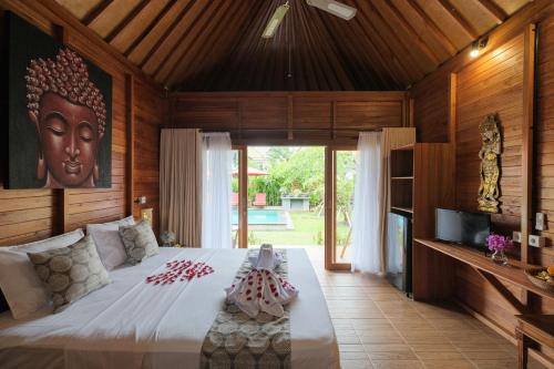 a bedroom with a large bed and a large window at Villa Felise in Sanur