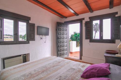 1 dormitorio con 1 cama, TV y ventanas en Villa con piscina privada - Benicolada en Calpe