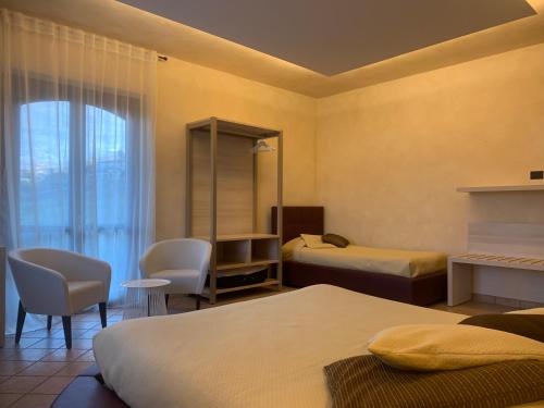 a hotel room with two beds and a window at Pernice 77 in Sulzano