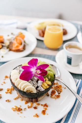 Eine Schüssel mit Essen auf einem Teller mit einer Blume darauf in der Unterkunft Eden Roc Miami Beach in Miami Beach