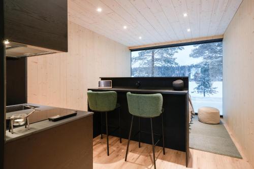 a kitchen with two bar stools and a large window at Kuuru Lakeside in Salla