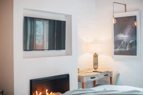 a bedroom with a fireplace and a table with a lamp at LOtel-Casa Arca in San Miguel de Allende