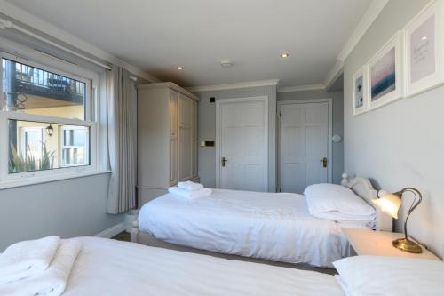 a bedroom with two beds and a window at Beachcombers Apartments in Newquay