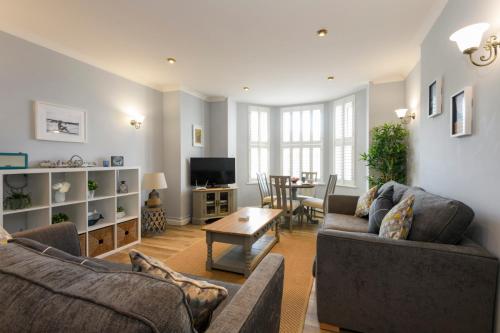 a living room with two couches and a table at Beachcombers Apartments in Newquay
