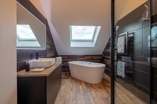 uma casa de banho com uma banheira grande e um lavatório em Gîte Serenida em Criquebeuf-sur-Seine