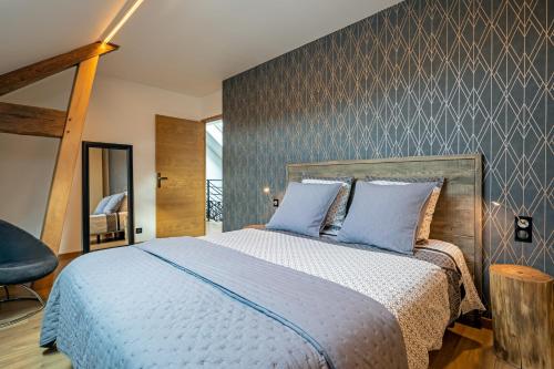 a bedroom with a large bed with blue pillows at Gîte Serenida in Criquebeuf-sur-Seine