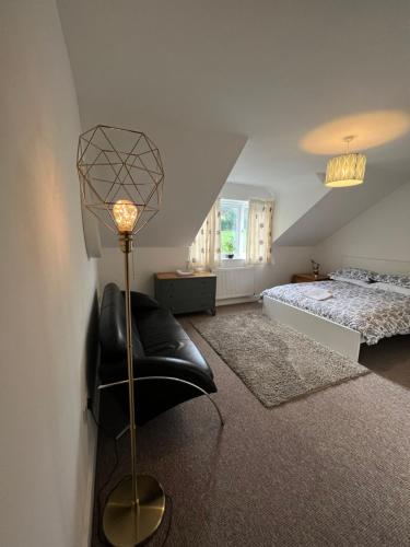 a bedroom with a black chair and a bed at Townhouse (C) in private grounds 8 mins from city in Dunston