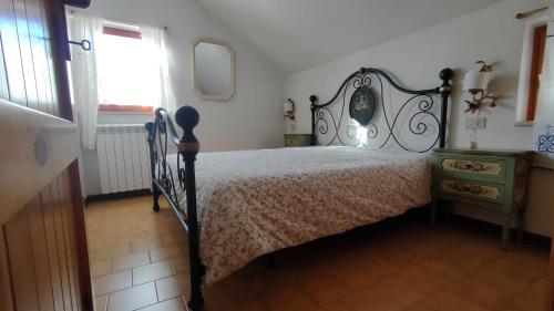 Appartamento Bucaneve في أوفندولي: غرفة نوم بسرير وخزانة ونافذة