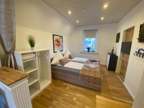 een kleine slaapkamer met een bed en een raam bij Ferienwohnung Maike in Lübeck