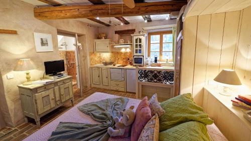 Cet appartement comprend une chambre avec une cuisine et un lit dans une pièce. dans l'établissement Remparts de Riquewihr - Refuge du Lutin - Studio, à Riquewihr