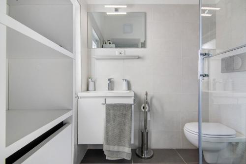 a white bathroom with a toilet and a sink at Casa sul Lago di Como in Pianello Del Lario