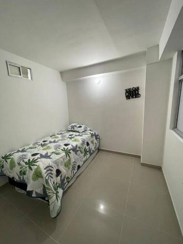 1 dormitorio con 1 cama en una habitación blanca en Aparta-hotel laureles 302, en Medellín