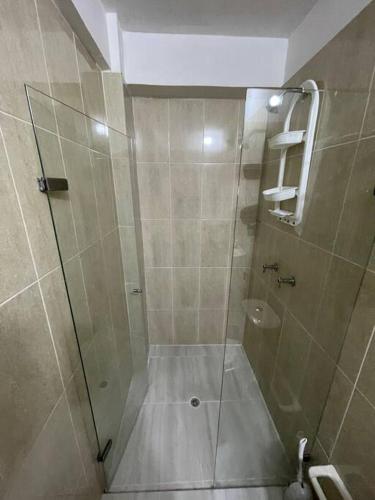 y baño con ducha y puerta de cristal. en Aparta-hotel laureles 302, en Medellín