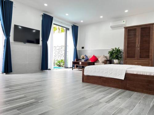 1 dormitorio con cama, TV y cortinas azules en Homestay Luna mountain & sea views! en Vung Tau