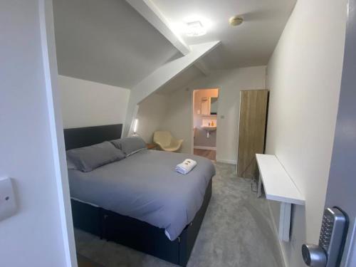 a small bedroom with a bed and a desk at Woodland Lodge in Hoddesdon