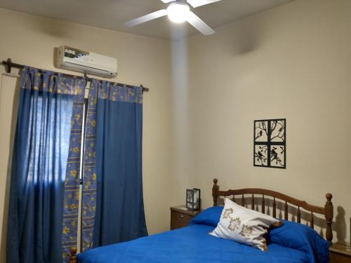 sypialnia z niebieskim łóżkiem i wentylatorem sufitowym w obiekcie Casa residencial en ubicación preferencial Dorrego w mieście Guaymallén
