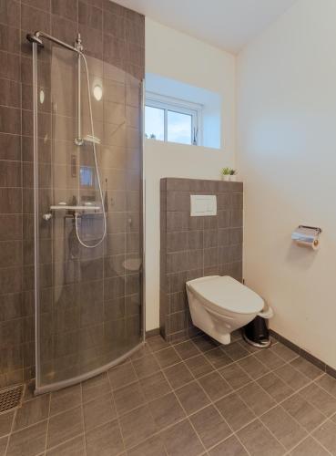 a bathroom with a shower with a toilet and a glass shower stall at New Boat House in Leirvík