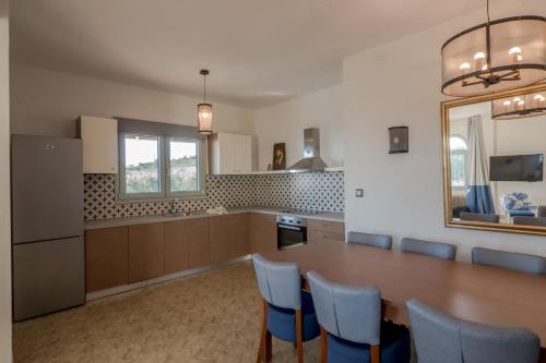 a kitchen with a wooden table and blue chairs at Asteris Village in Gerakini