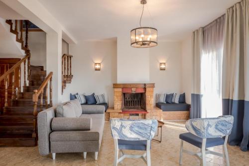 a living room with a couch and chairs and a fireplace at Asteris Village in Gerakini