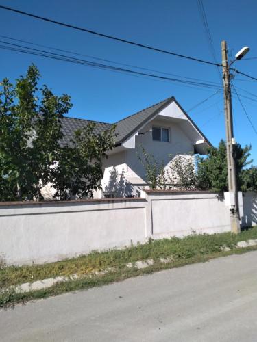 a white house behind a white fence at Casa Gabi in Corbu