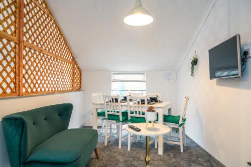 a living room with a green couch and a table at Elegant 4BR Little Venice By Aureva Residences in London