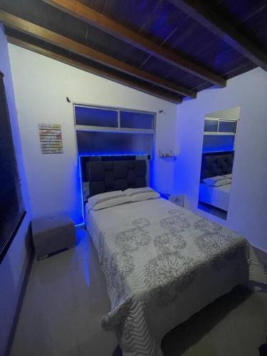 1 dormitorio con 1 cama en una habitación azul en Aparta-hotel laureles 401, en Medellín