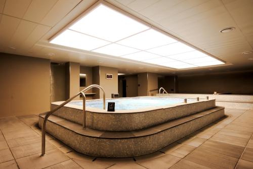 a large bath tub in a room with a skylight at Lotte Hotel Busan in Busan
