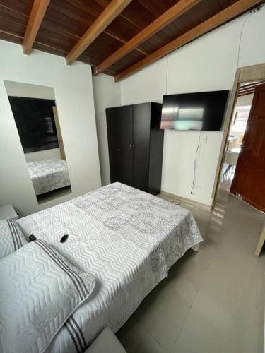 1 dormitorio con 1 cama y TV. en Aparta-hotel laureles 401, en Medellín