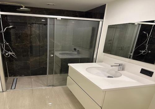 a bathroom with a white sink and a shower at Prime İstanbul Residances Deluxe King Studio in Istanbul