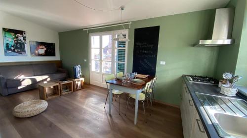 a kitchen and living room with a table and a couch at LuccaStay in Lucca