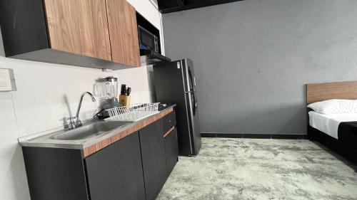 eine kleine Küche mit Spüle und Kühlschrank in der Unterkunft Venecia Loft in Medellín