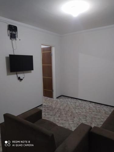 Habitación con TV en la pared en Apartamento no centro de Vicosa-ce, en Viçosa do Ceará