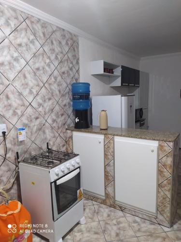 a kitchen with a stove and a counter top at Apartamento no centro de Vicosa-ce in Viçosa do Ceará