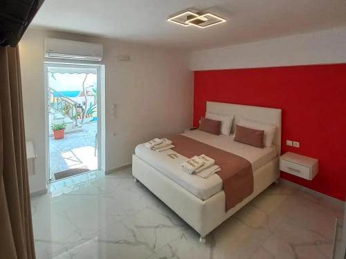 a bedroom with a large bed with a red wall at House Blerina in Sarti