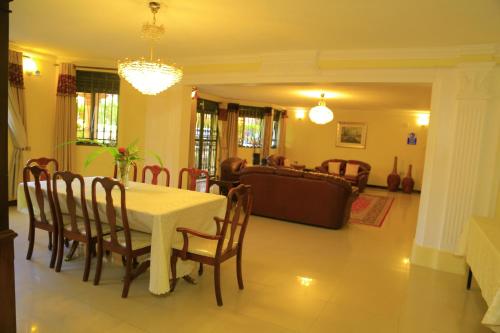 a dining room and living room with a table and chairs at Royal Victoria House Ltd in Kampala